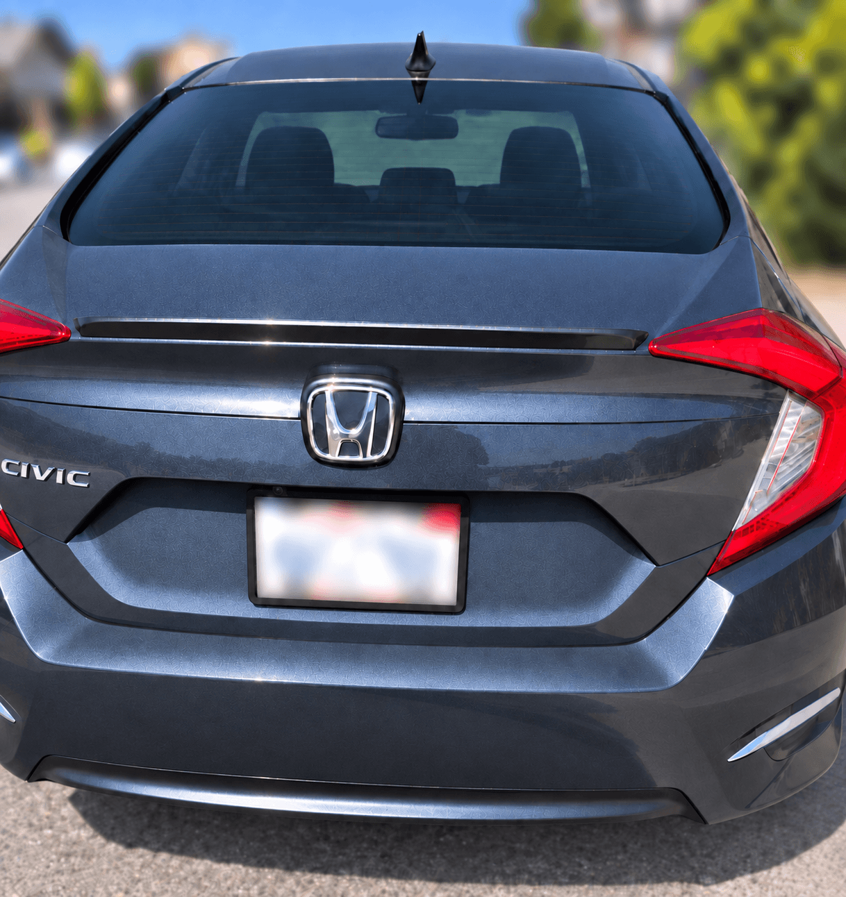 Rear of the blue Honda Civic after detailing, showing the cleaned rear glass, trunk, and bumper.